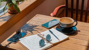 Cafe table with a diary, sunglasses and coffee