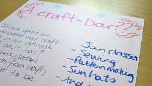 Photograph of a hand-drawn news story from the future about a craft shop